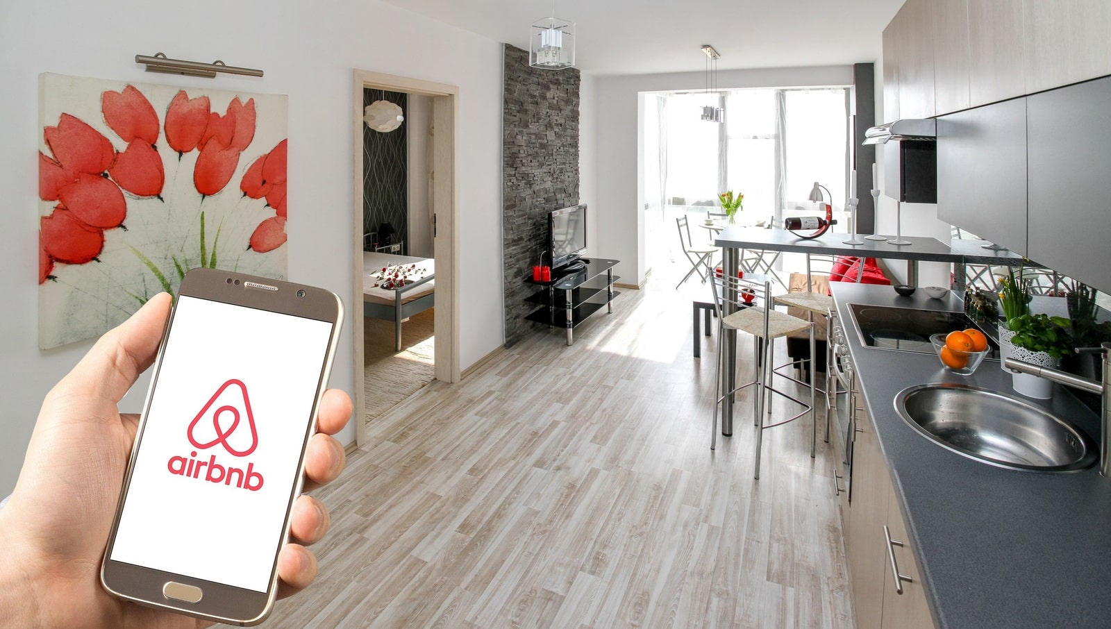 Image of a rented apartment and the mobile version of Airbnb as one of the channels supported by channel managers.