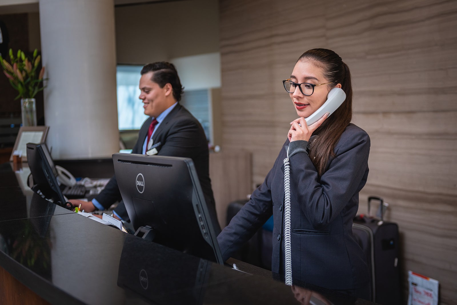 Photograph of hotel front desk employees dealing with direct bookings.