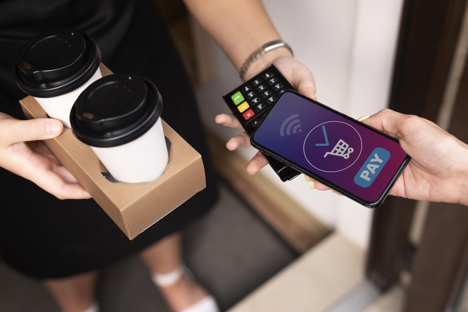 Photograph of a person paying for services with a phone using Apple Pay.