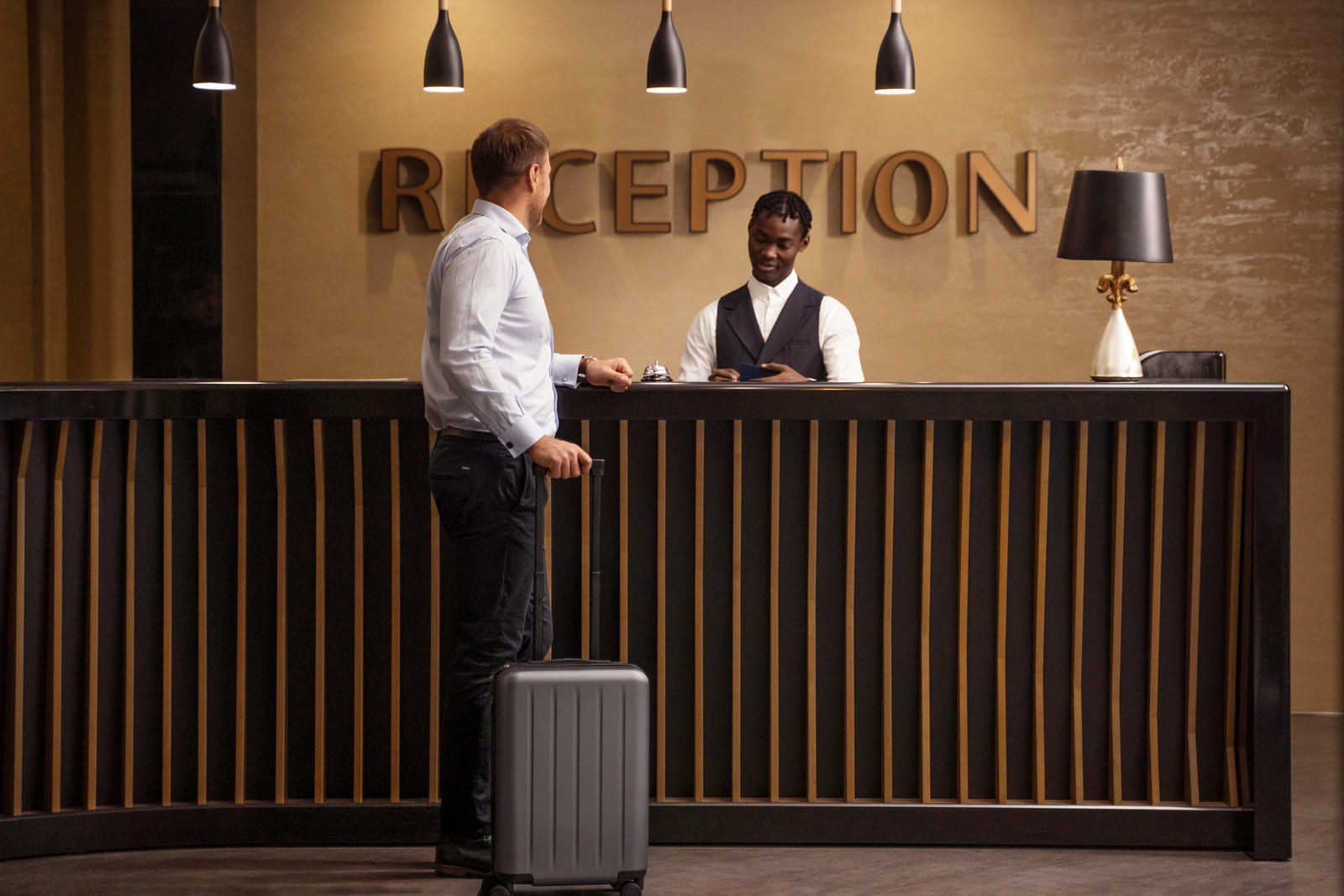 Visual of reception and front desk employee dealing with a new guest.