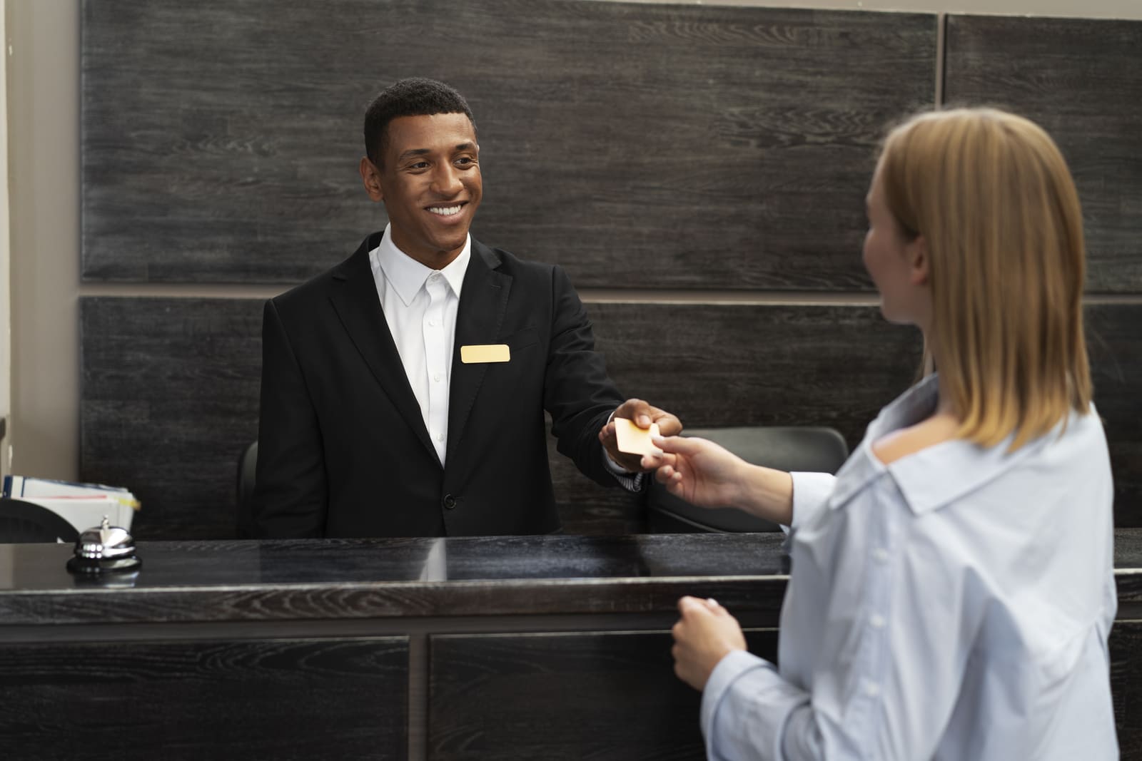 Image of a receptionist receiving the credit card from the potential guest.