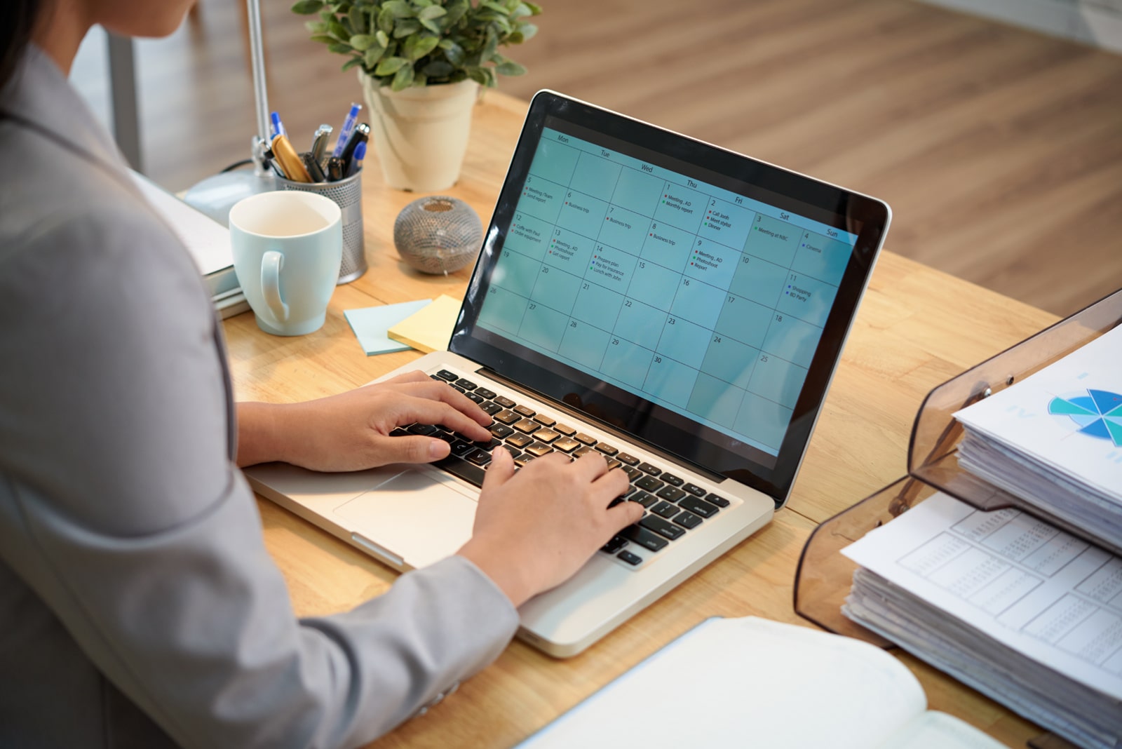 Photograph of a woman using an online calendar similar to that of Vik Rent Car.