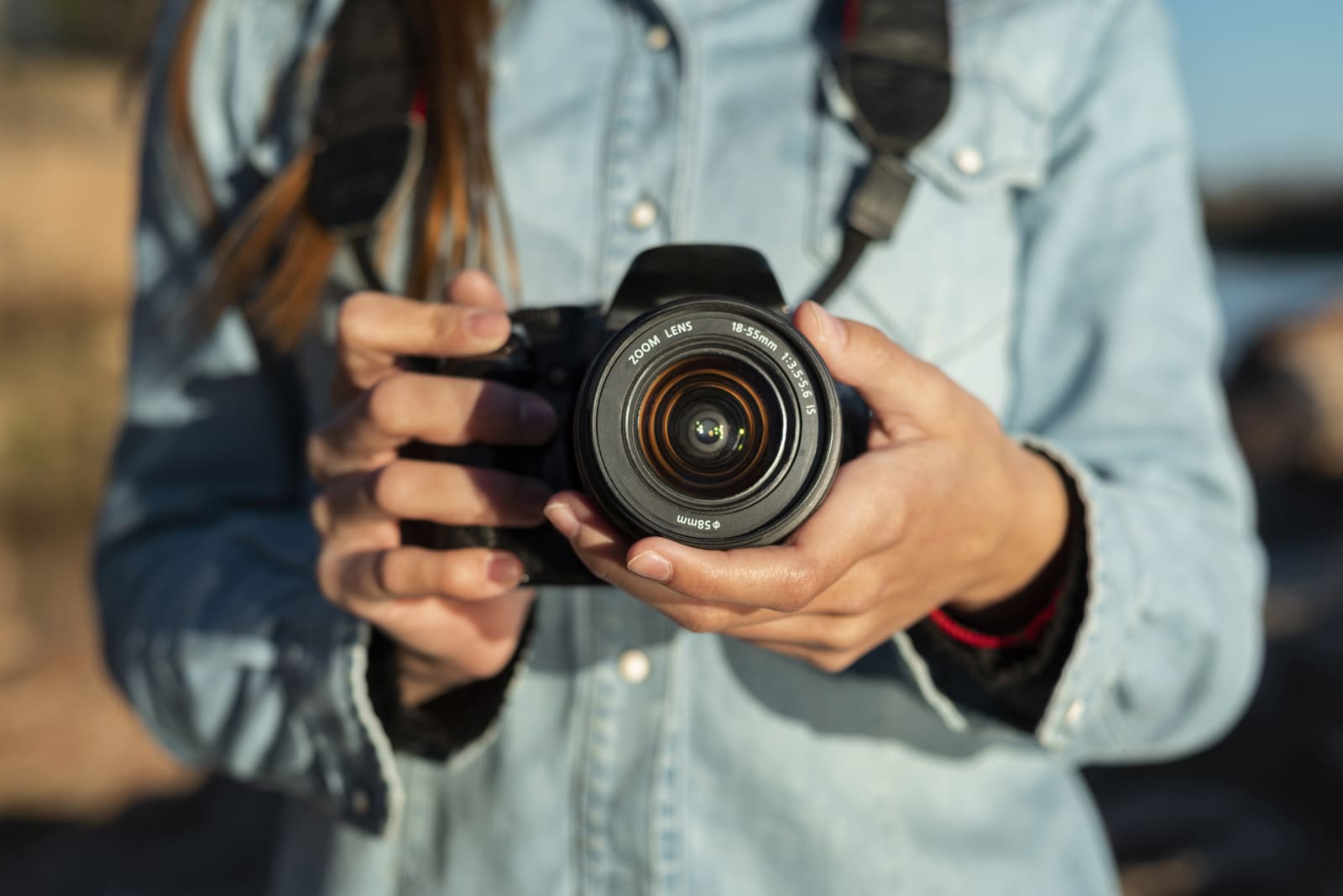 Photograph of a woman holding a camera to create bed and breakfast hotel photos.